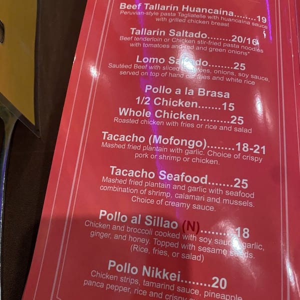 A close-up view of a red menu displaying various Peruvian special dishes and their prices.