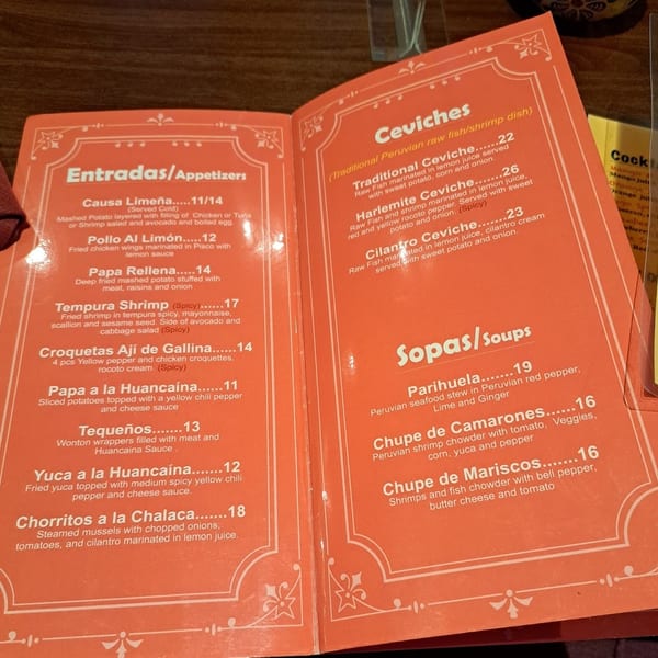 An open orange menu displays appetizers, ceviches, and soups with descriptions and prices.