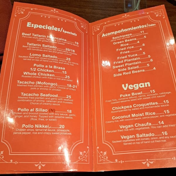 A close-up view of a Peruvian restaurant's menu, featuring specials, sides, and vegan options.