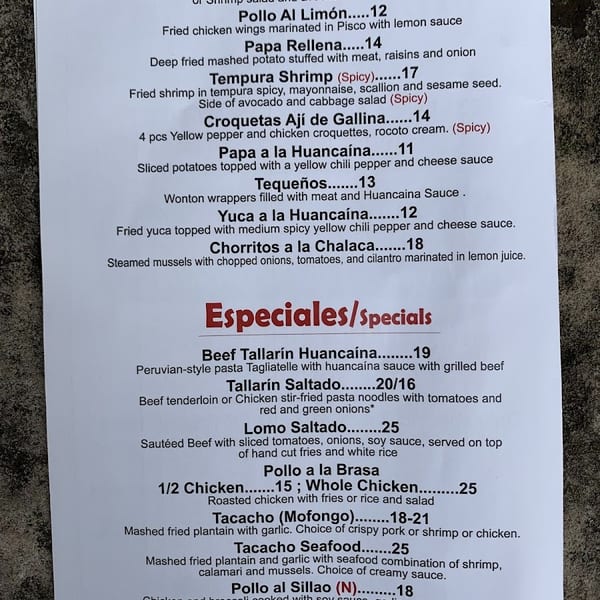 A white paper menu displays a list of Peruvian appetizers and specials with descriptions and prices.